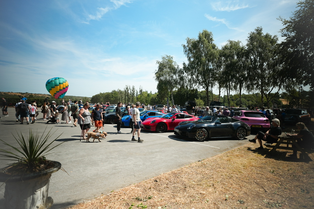 Crowd, hot air balloon and Porsches