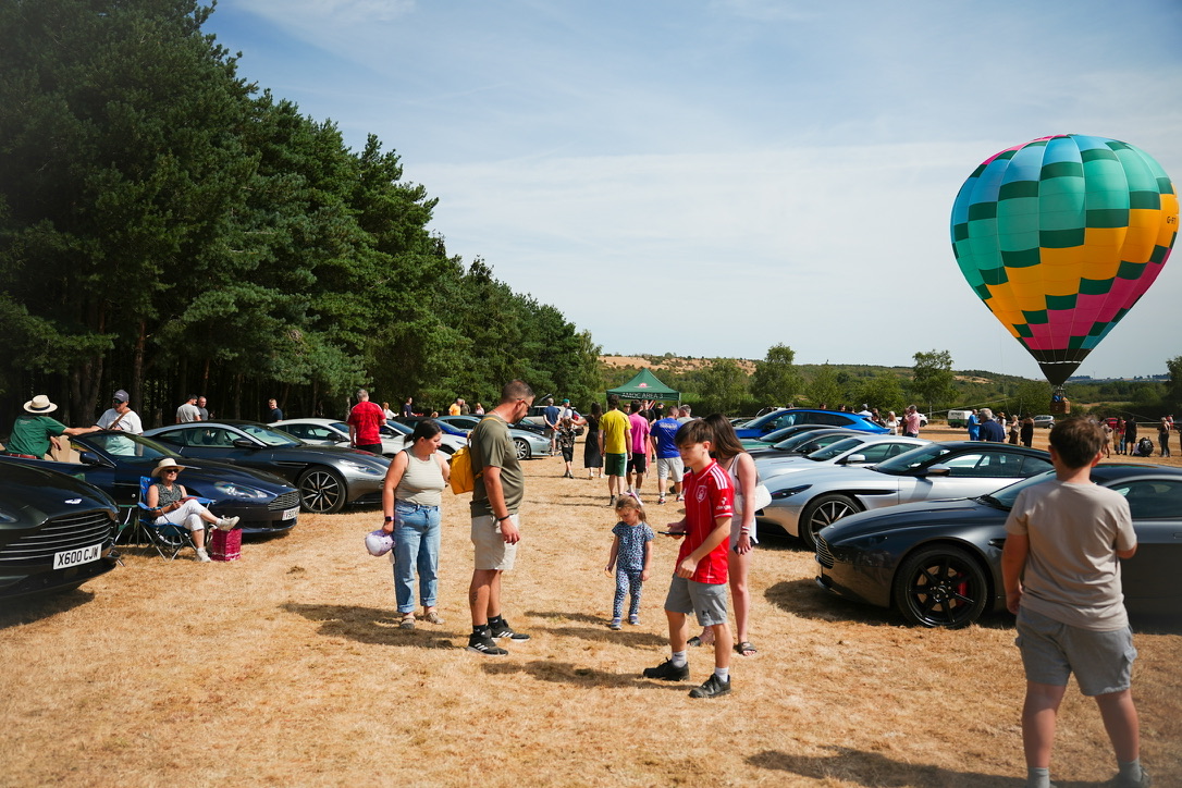 Crowd, hot air balloon and Aston Martins
